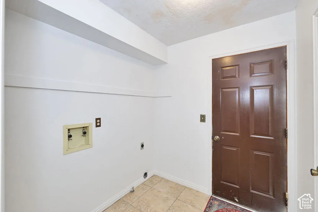 Utility area featuring tile flooring, a six-panel door, and built-in shelving