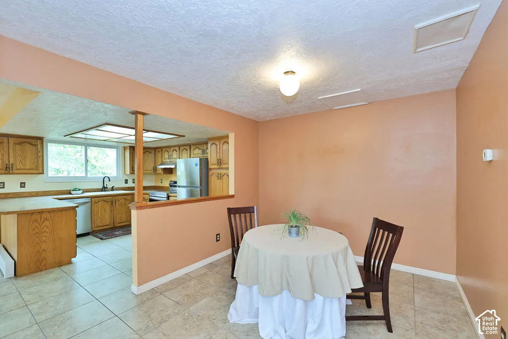 Kitchen featuring wood cabinetry, laminate countertops, and tile flooring