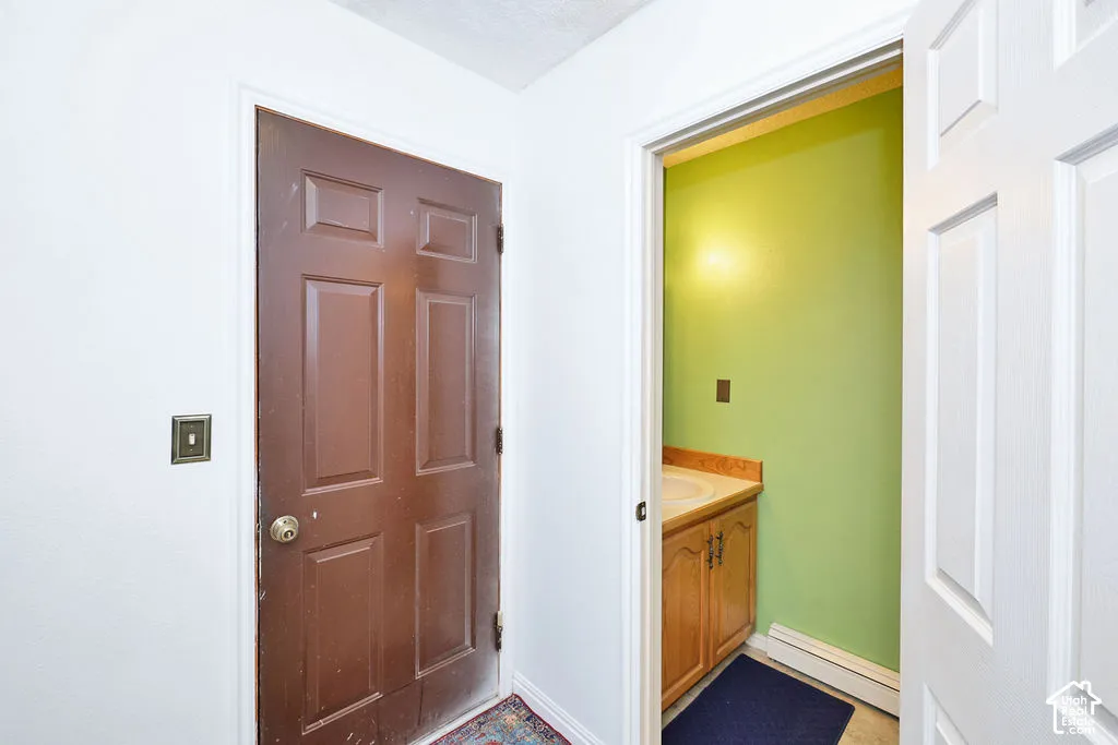 Six-panel solid-core door with metallic hardware, light wood-finish cabinetry, and inset basin