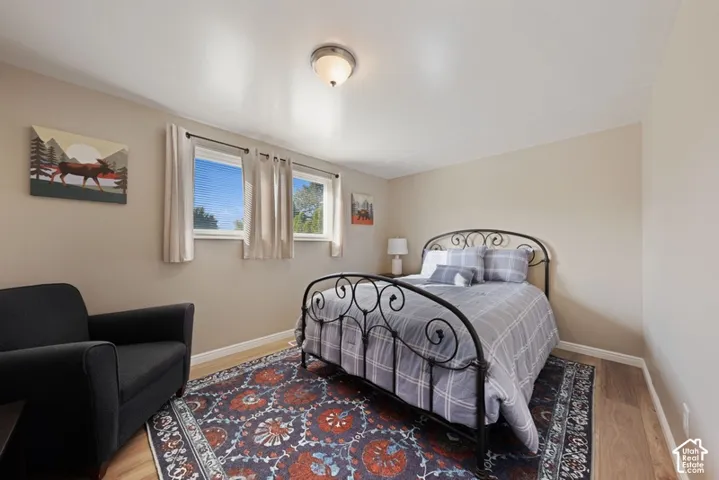 Neutral-toned walls, wood-finish flooring, dual windows with exterior exposure, and a flush-mount ceiling light fixture