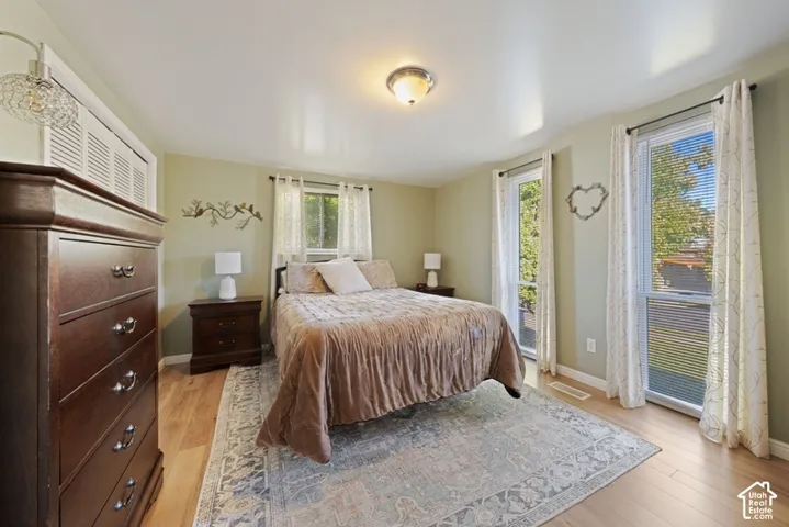 Wood-finish flooring, dual vertical windows, and louvered closet doors