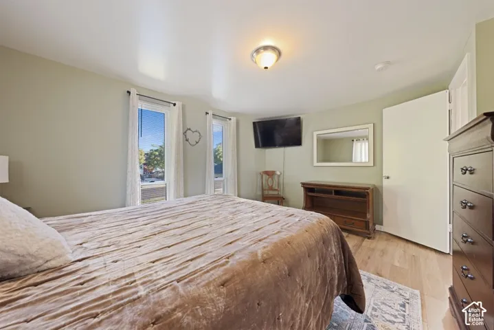 Room featuring light-toned wood-finish flooring, two vertical windows, and a central flush-mount light fixture
