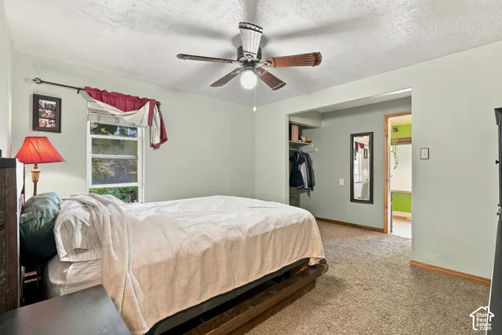 Room featuring neutral wall tones, carpeted flooring, a ceiling fan, and a built-in closet