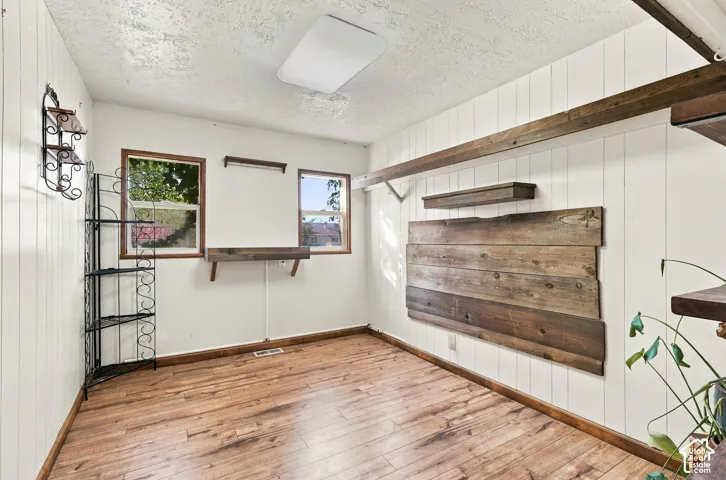 Vertical wood-panel walls, wood-finish flooring, and built-in rustic timber shelving featuring natural wood-grain detailing