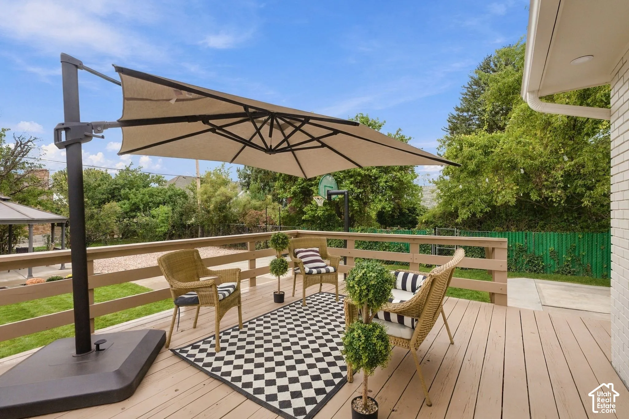 Elevated wooden deck with horizontal rail fencing, spanning over a landscaped backyard