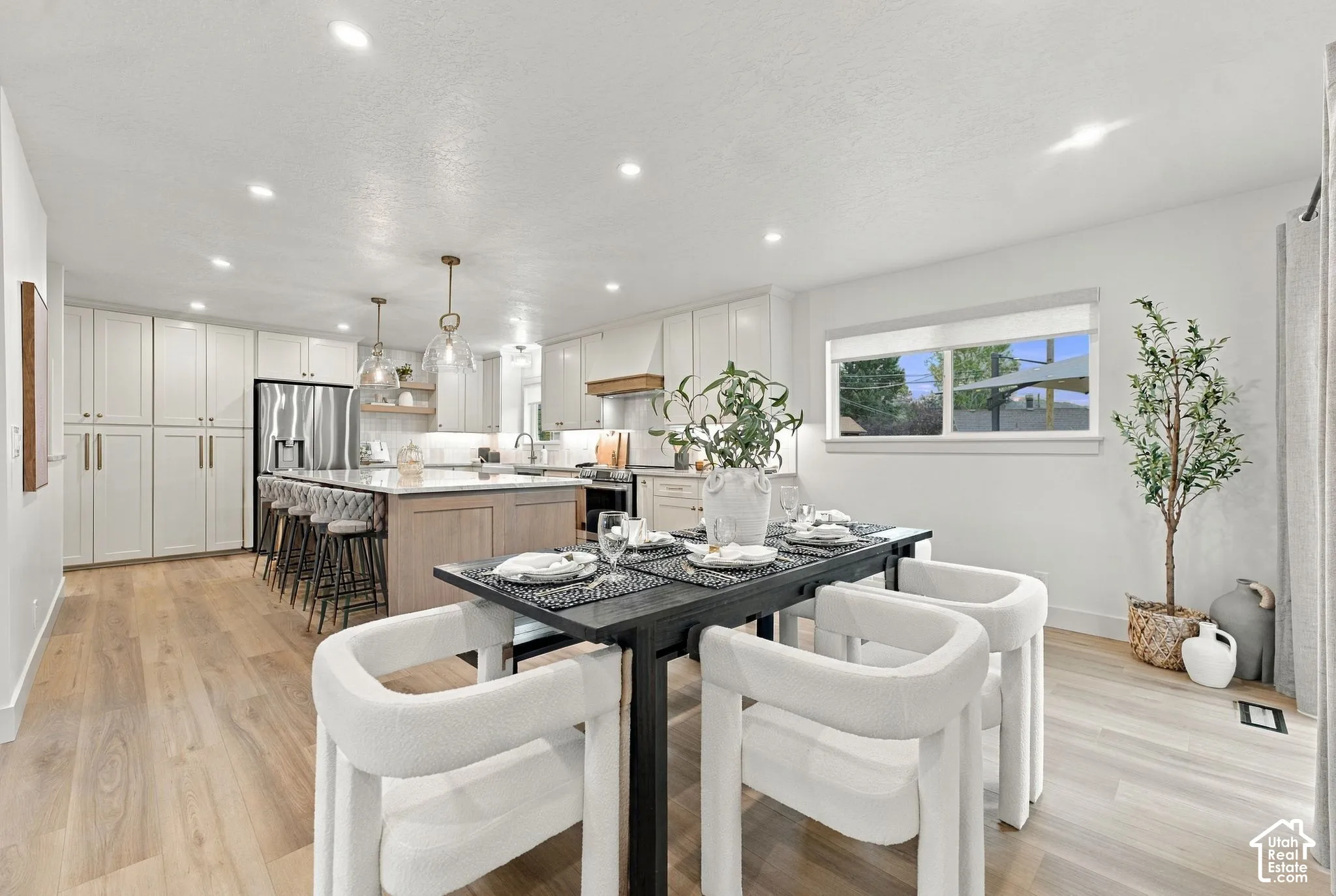 Kitchen featuring shaker-style cabinetry, a central island with a stone countertop, recessed ceiling lighting, and wood-finish flooring