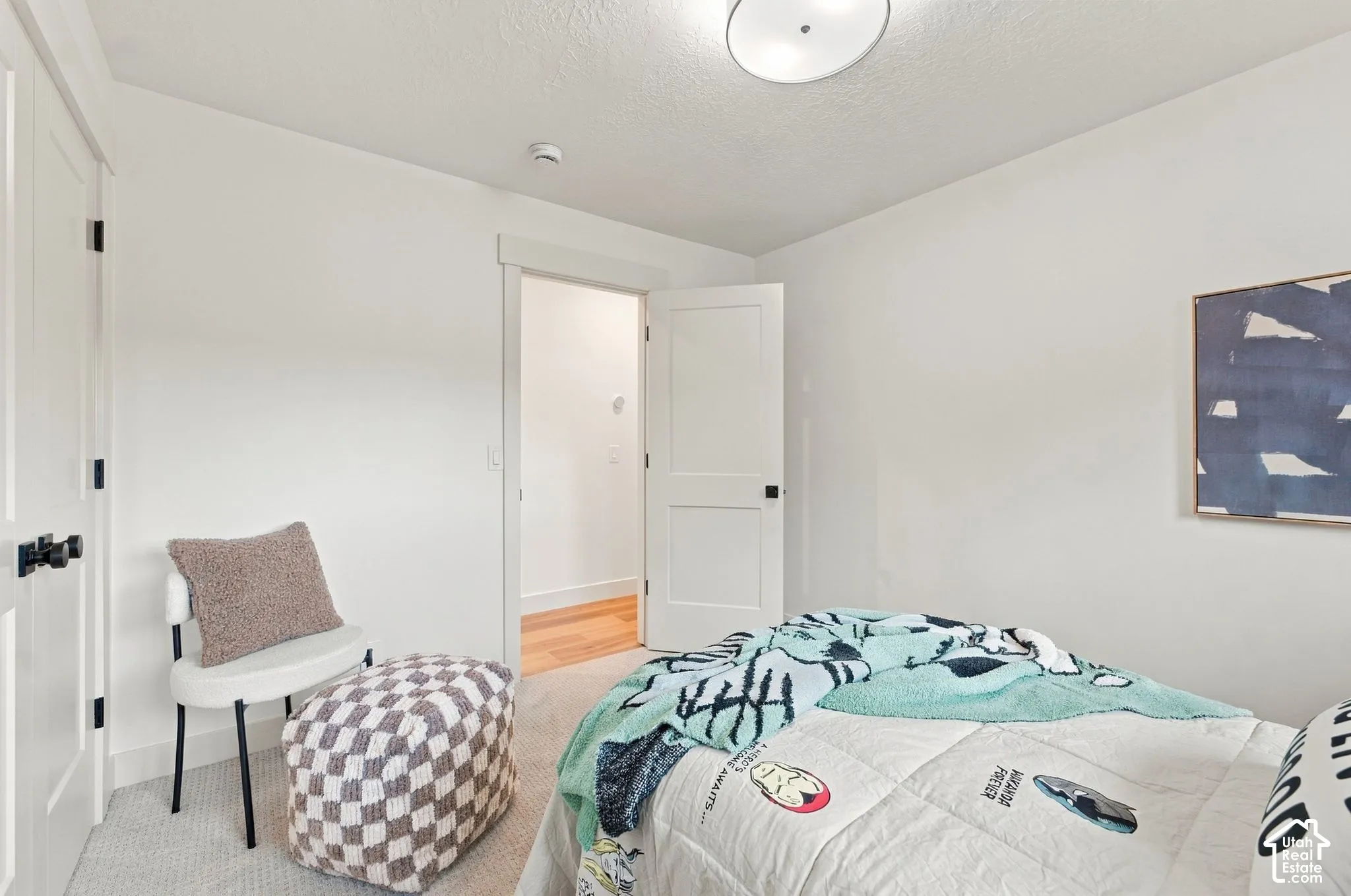Bright secondary bedroom featuring white painted walls, recessed ceiling lighting, and hardwood flooring