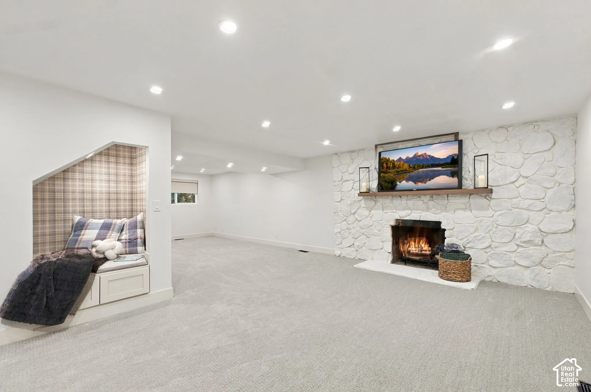 Living area featuring a floor-to-ceiling painted stone fireplace, natural wood mantel, recessed lighting, carpeted flooring, and a built-in nook with cabinetry