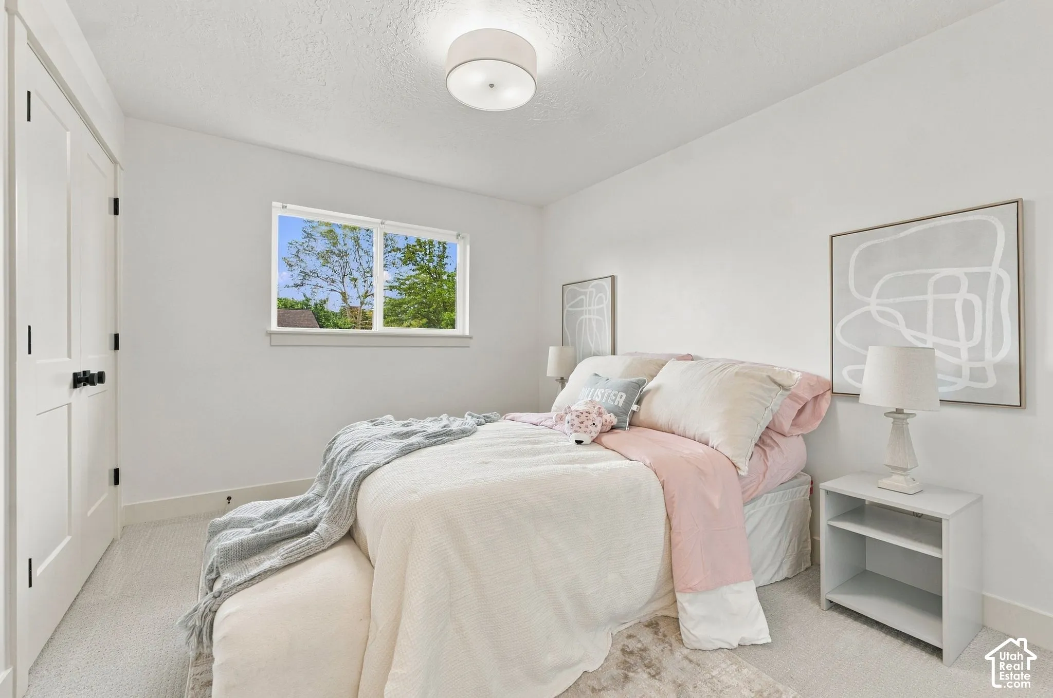 Neutral interior featuring crisp white walls, neutral-toned carpeting, a multi-panel interior door with matte black hardware, and a flush-mount circular ceiling fixture