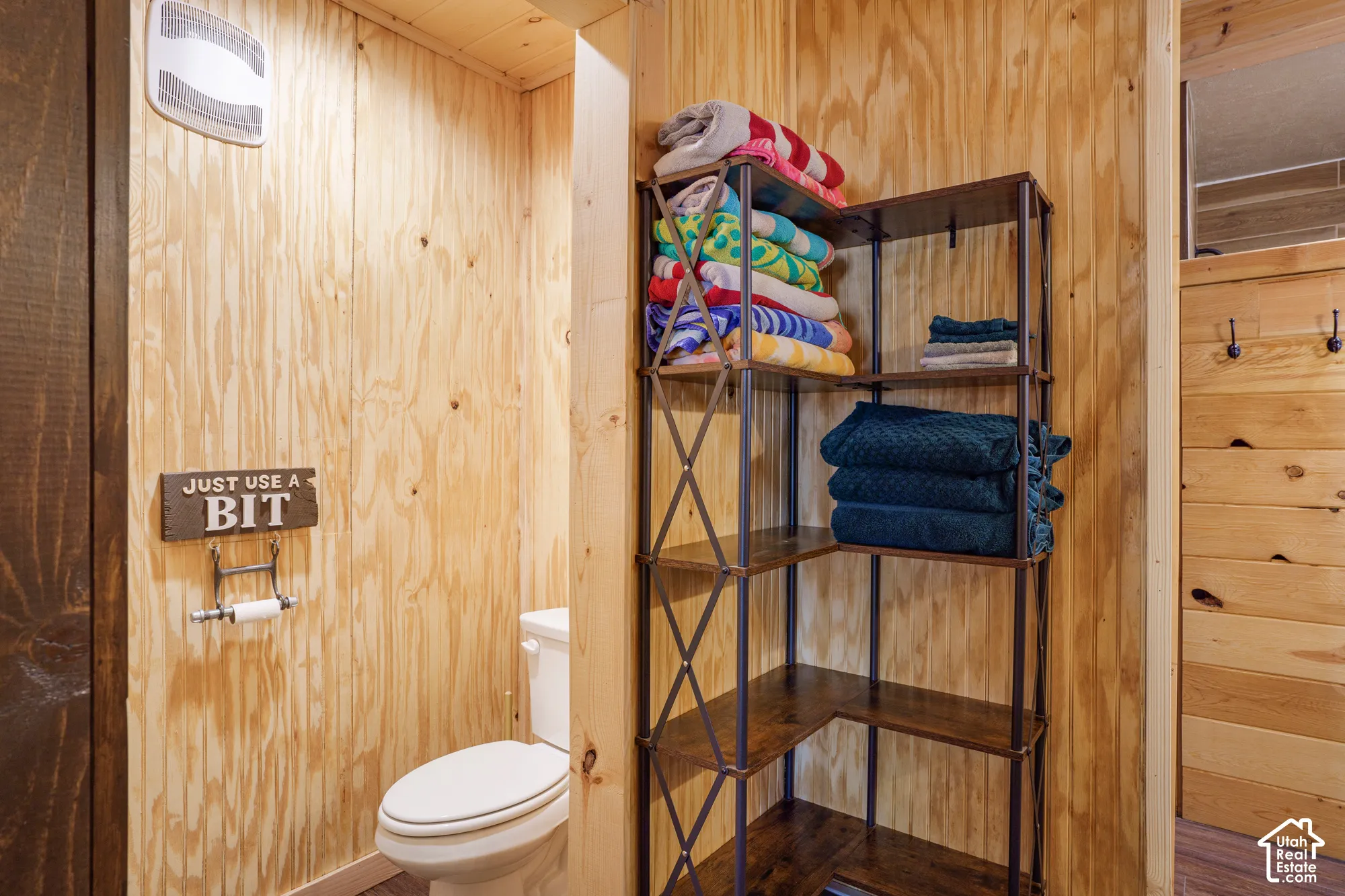 Natural plywood wall paneling, standard height toilet, and wood-finish ceiling planks