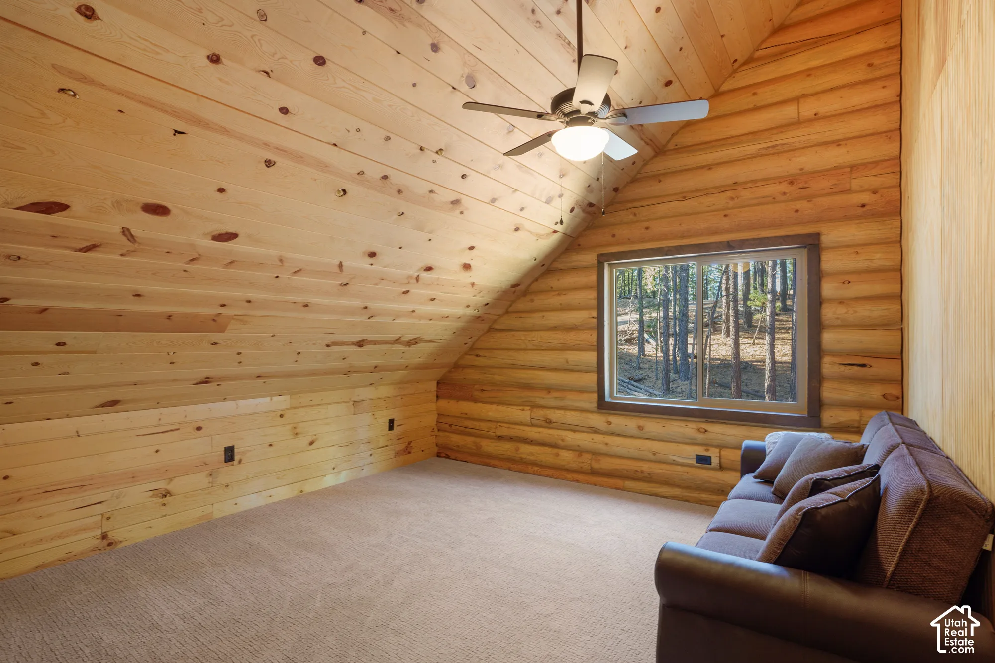 Vaulted ceilings with exposed timber wall paneling, knotty pine finish, carpeting, and a ceiling fan