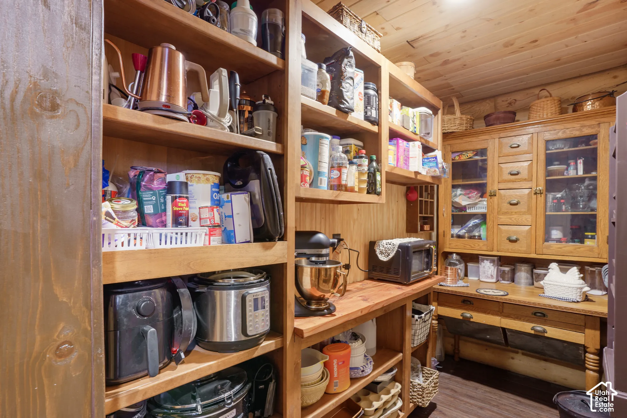Custom built-in wood cabinetry, integrated shelving units, natural wood-finish plank ceiling, and wood-finish flooring
