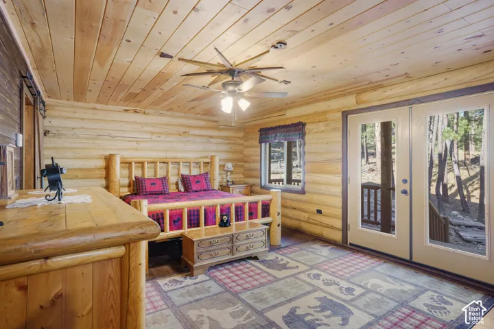 Interior space featuring exposed log walls, natural wood-plank ceiling, and glass-paneled double doors