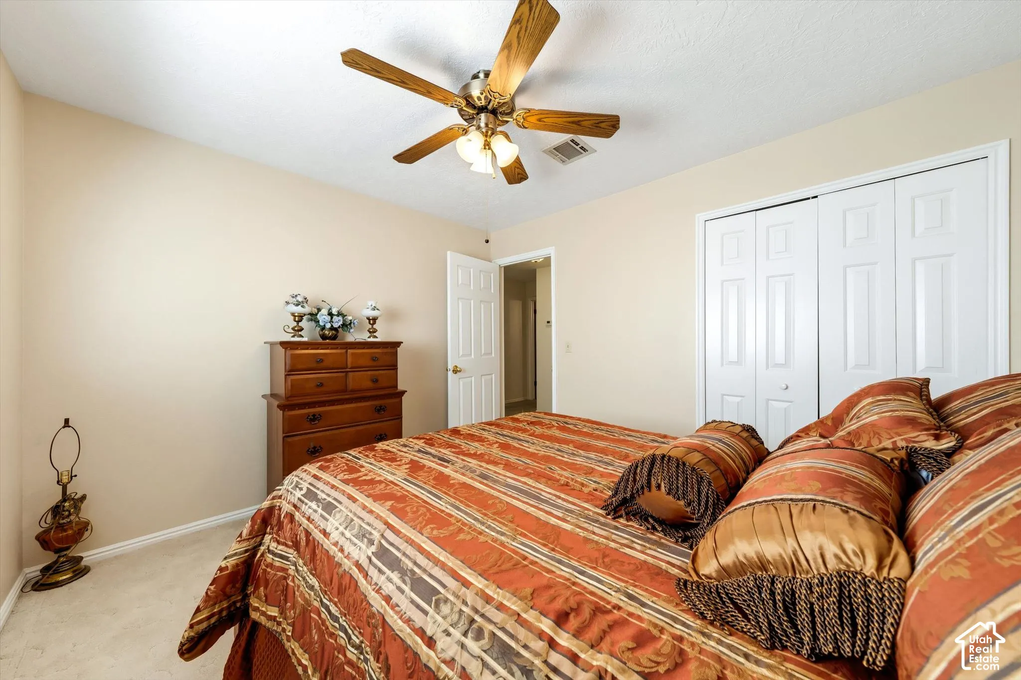 Neutral wall coloring, ceiling fan with light fixture, and dual-panel closet doors