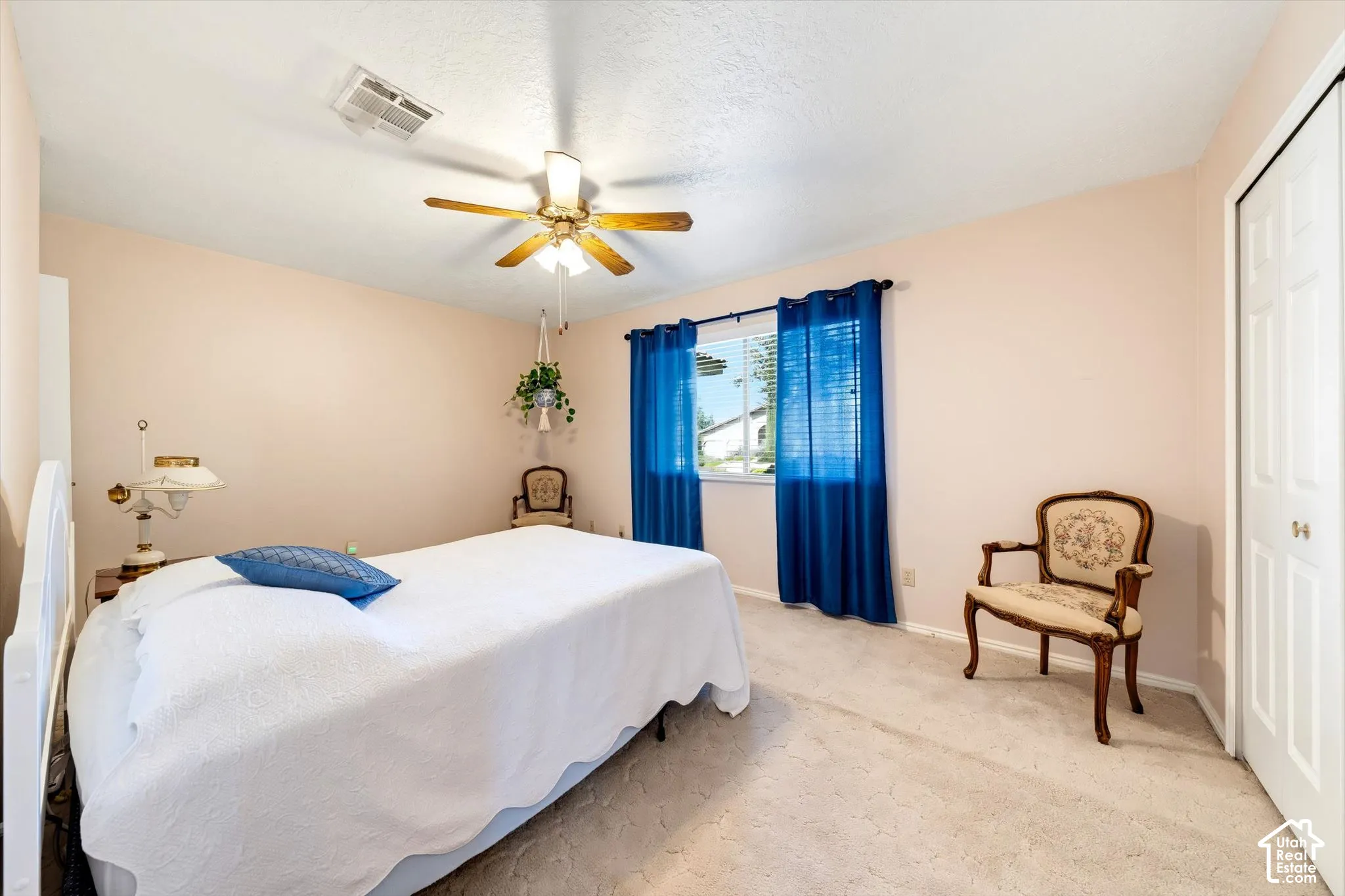 Neutral interior space featuring carpeted flooring, a ceiling fan with integrated lighting, and a closet with double-panel doors
