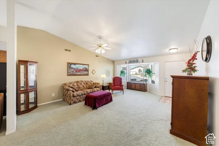 Vaulted ceilings, carpeted flooring, built-in bay window, and a central ceiling fan