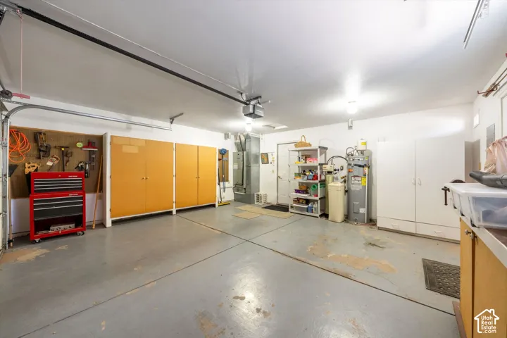 Multi-car garage featuring expansive built-in cabinetry, smooth-finish concrete flooring, and an automated overhead door system