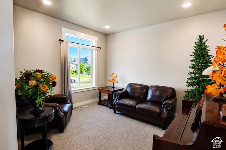 Neutral interior space featuring recessed ceiling lighting, wall-to-wall carpeting, and a large window with white trim