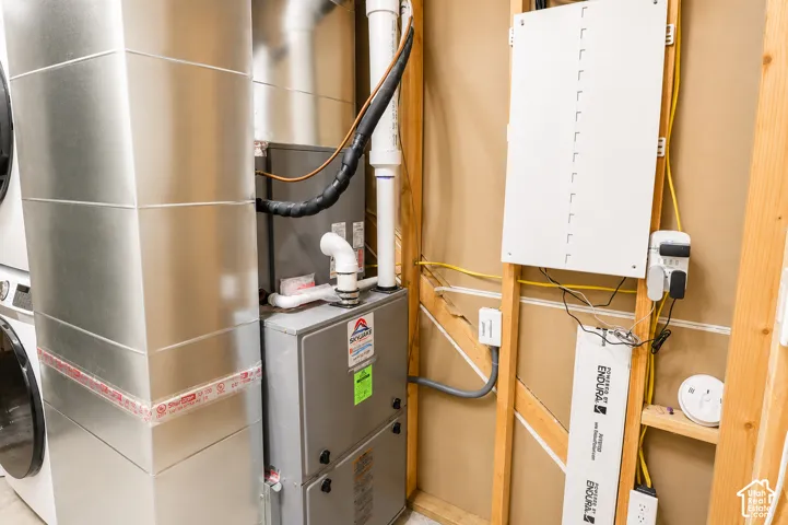 Utility area featuring a high-efficiency forced air furnace, galvanized metal ductwork, and an exposed wood-frame wall with an electrical panel