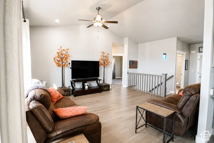 Vaulted ceilings, wood-finish flooring, and a ceiling fan with integrated lighting