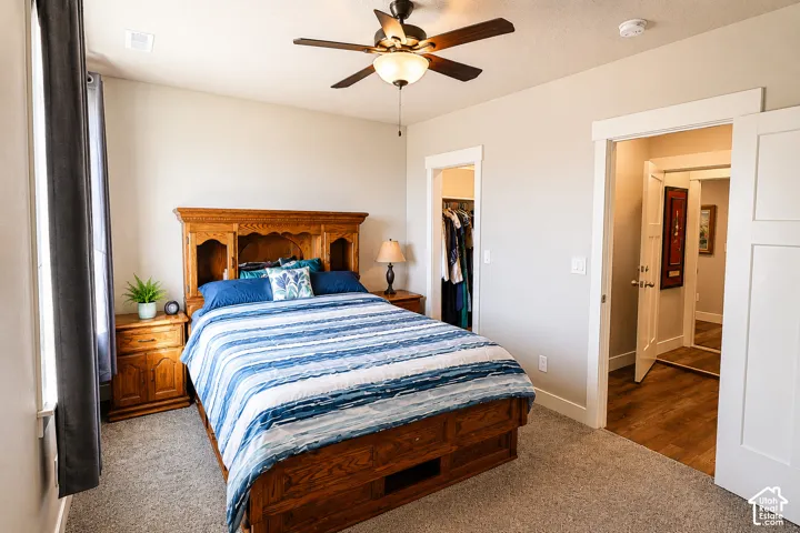 Neutral-toned interior featuring carpeting, a multi-blade ceiling fan with integrated lighting, and white door casings
