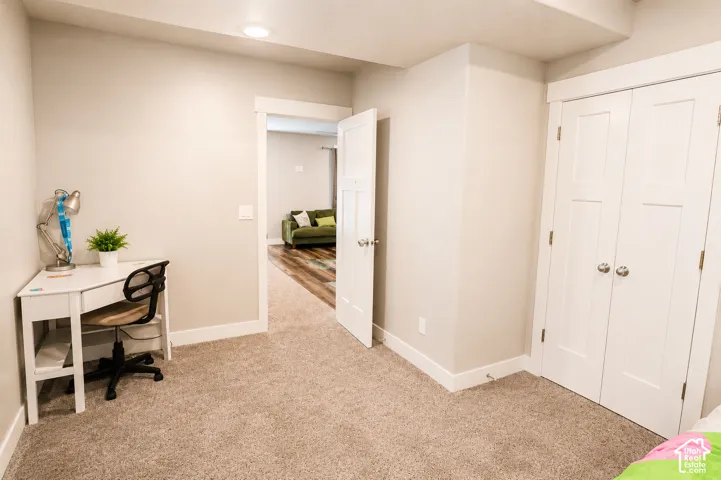 Neutral-toned carpeting, white interior doors with satin nickel hardware, and double-panel closet doors