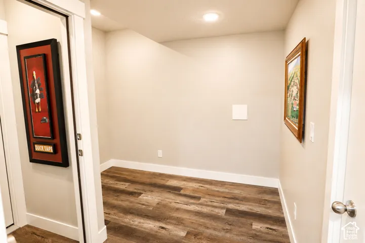 Wood-finish flooring, recessed ceiling lighting, and crisp neutral wall paint