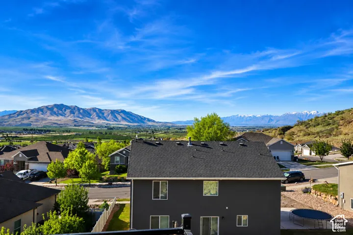 Two-story residence featuring a dark-toned exterior, asphalt shingle roof, and expansive backdrop of mountain ranges
