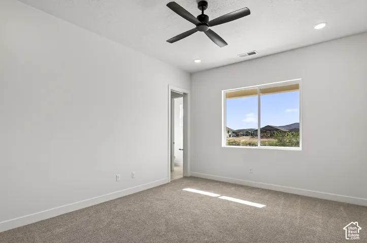Interior room featuring neutral wall paint, carpet flooring, a matte black ceiling fan, and recessed lighting