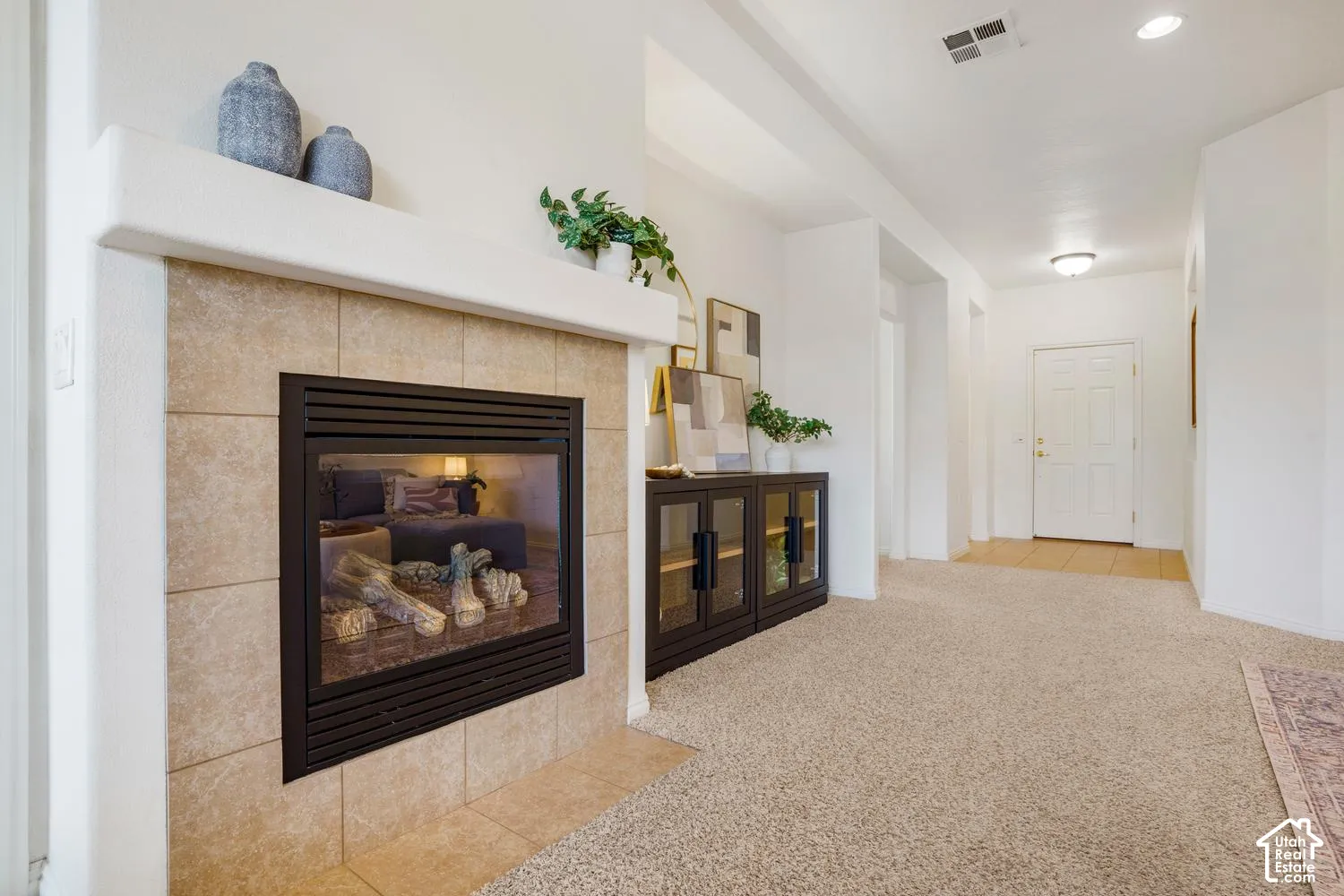 Fireplace featuring a custom tile surround, neutral mantle, and matte black frame