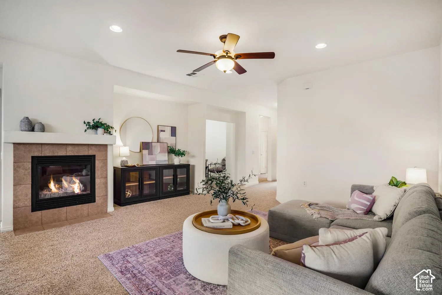 Fireplace featuring a tiled surround and mantel, recessed ceiling lighting, and a multi-blade ceiling fan