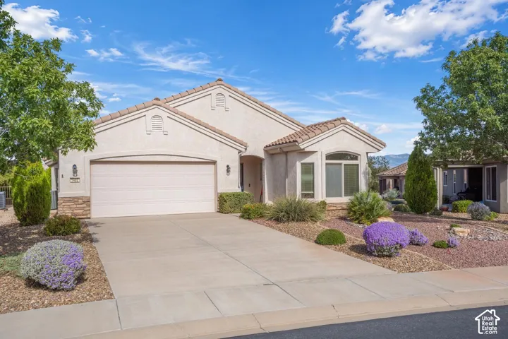 Single-story stucco exterior with stone accents, tile roof, and two-car garage
