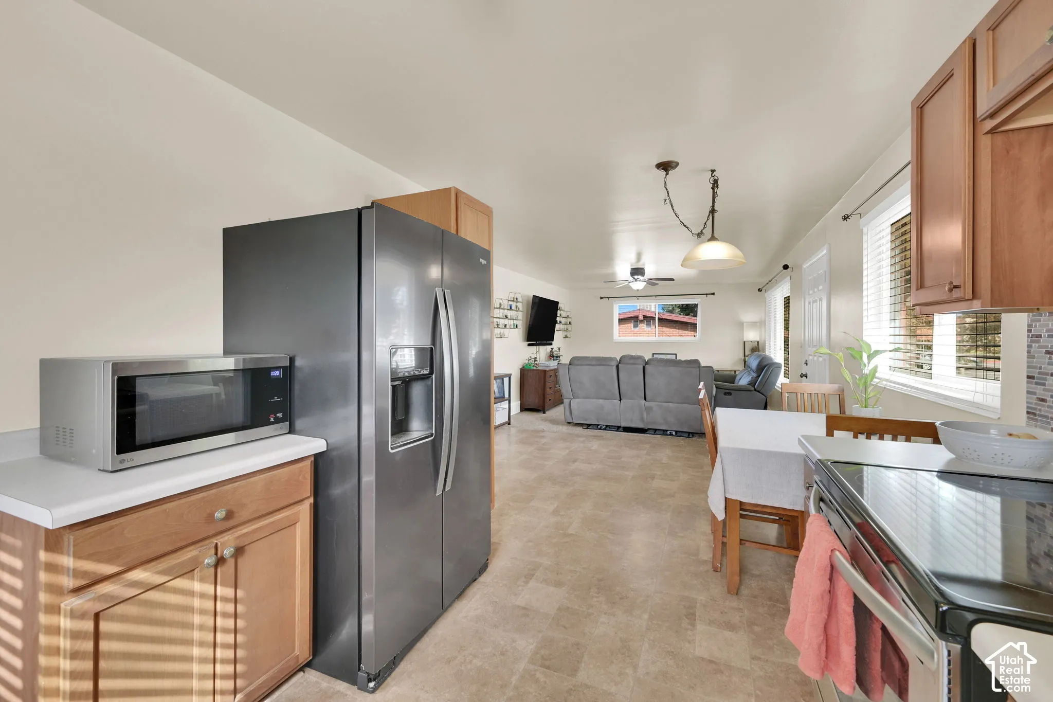 Kitchen featuring wood cabinetry, solid-surface countertops, tile flooring, and pendant lighting