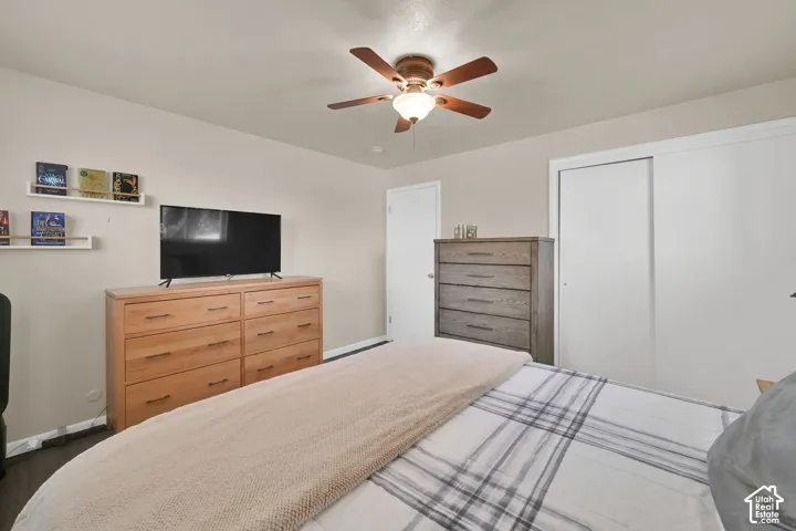 Ceiling fan with integrated light fixture, sliding-door closet, and floating wall-mounted shelving