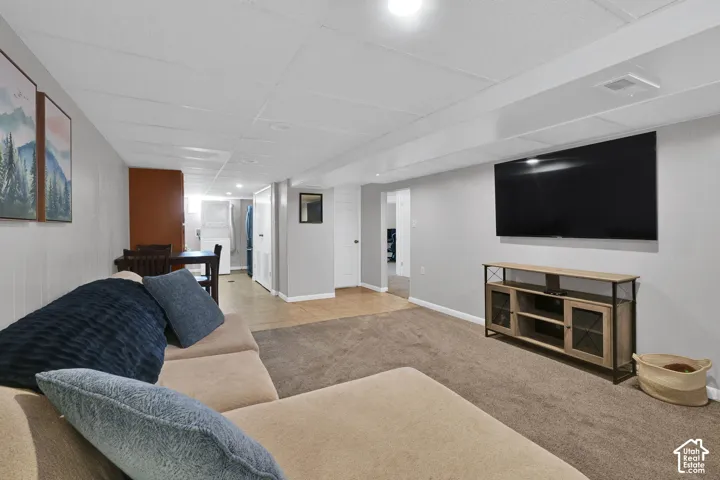 Finished area featuring wall-to-wall carpeting, neutral interior paint, and tile flooring