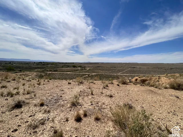 Expansive landscape featuring high-desert terrain, native vegetation, and distant mountain silhouettes