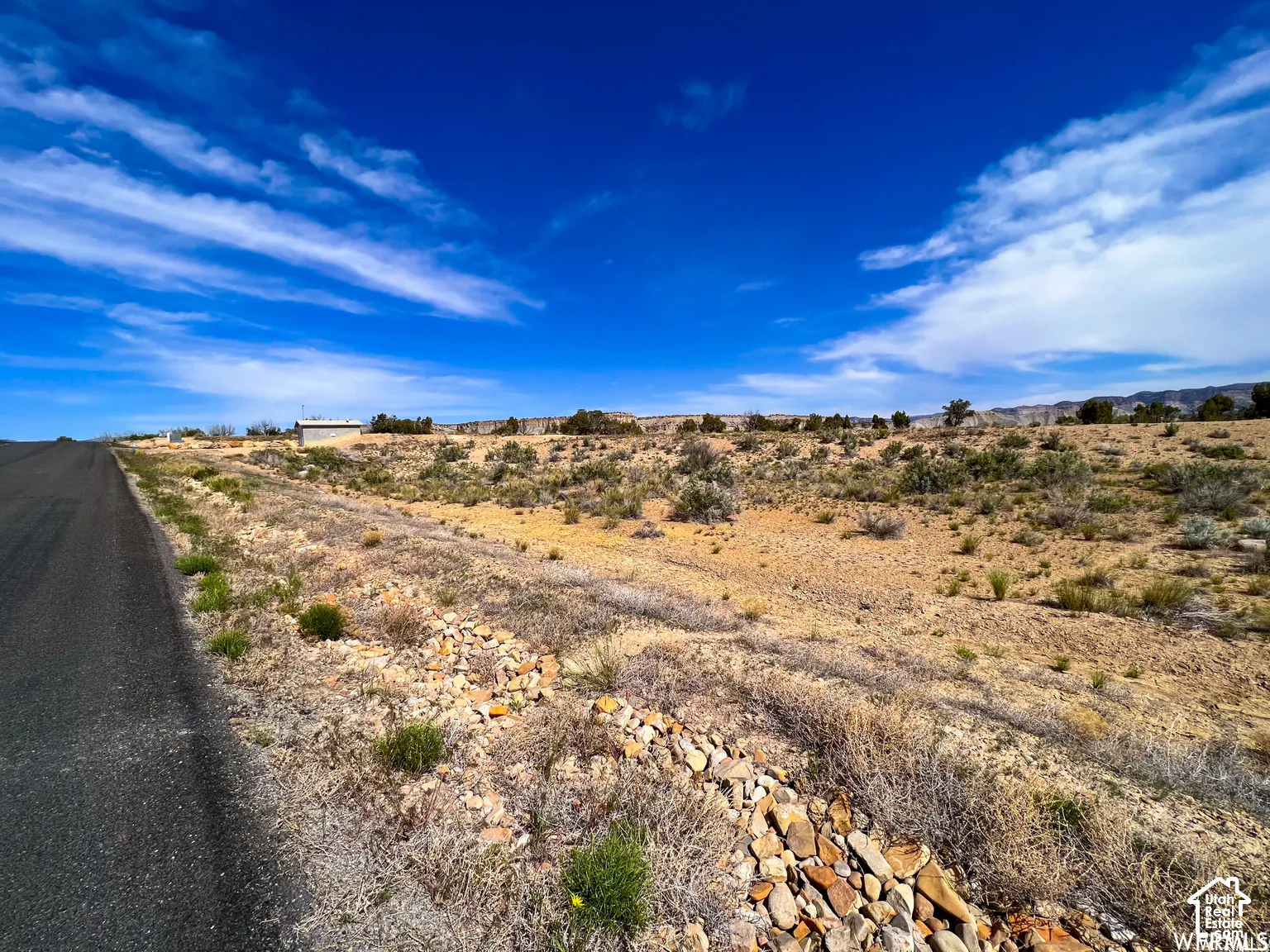 Expansive desert parcel featuring paved road frontage, natural topography, native vegetation, and a mountainous backdrop