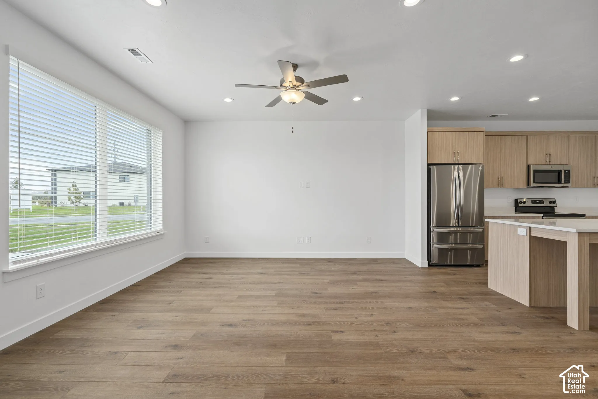 Open-concept interior featuring wood-finish flooring, recessed lighting, and a ceiling fan
