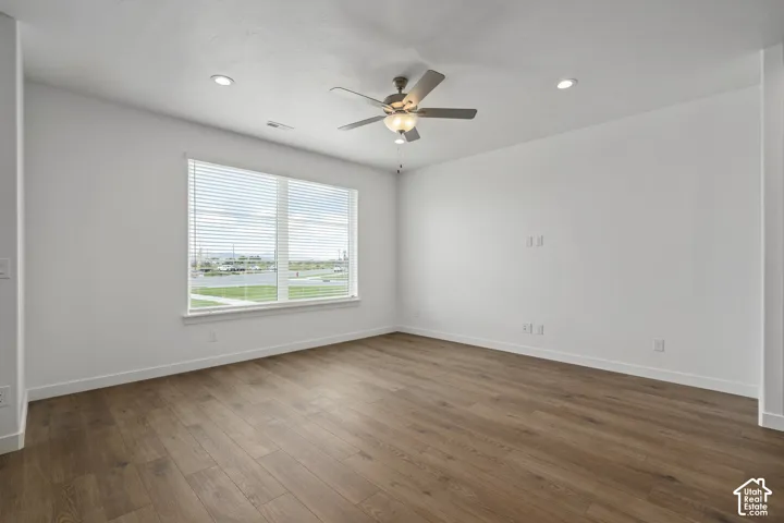 Room featuring wood-finish flooring, recessed lighting, and a central ceiling fan