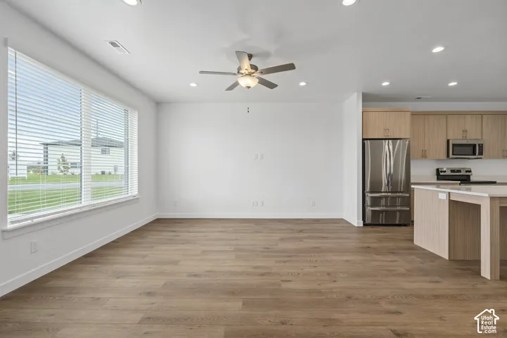 Open-concept interior featuring wood-finish flooring, recessed lighting, and a ceiling fan