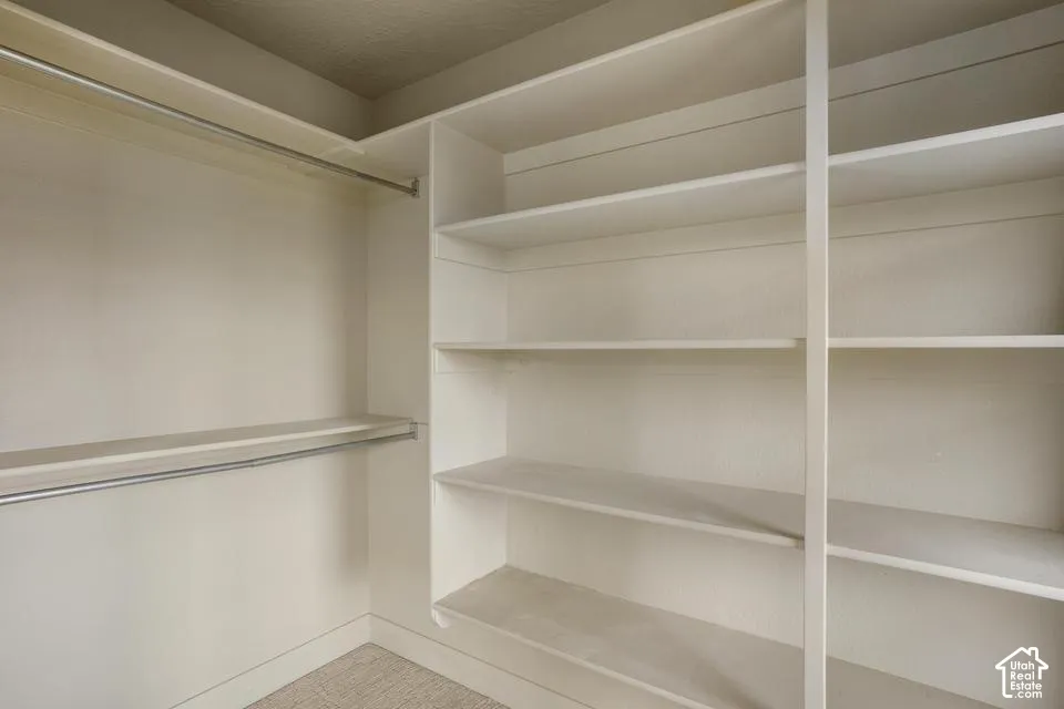 Built-in storage system featuring floor-to-ceiling shelving and dual metal clothing rods