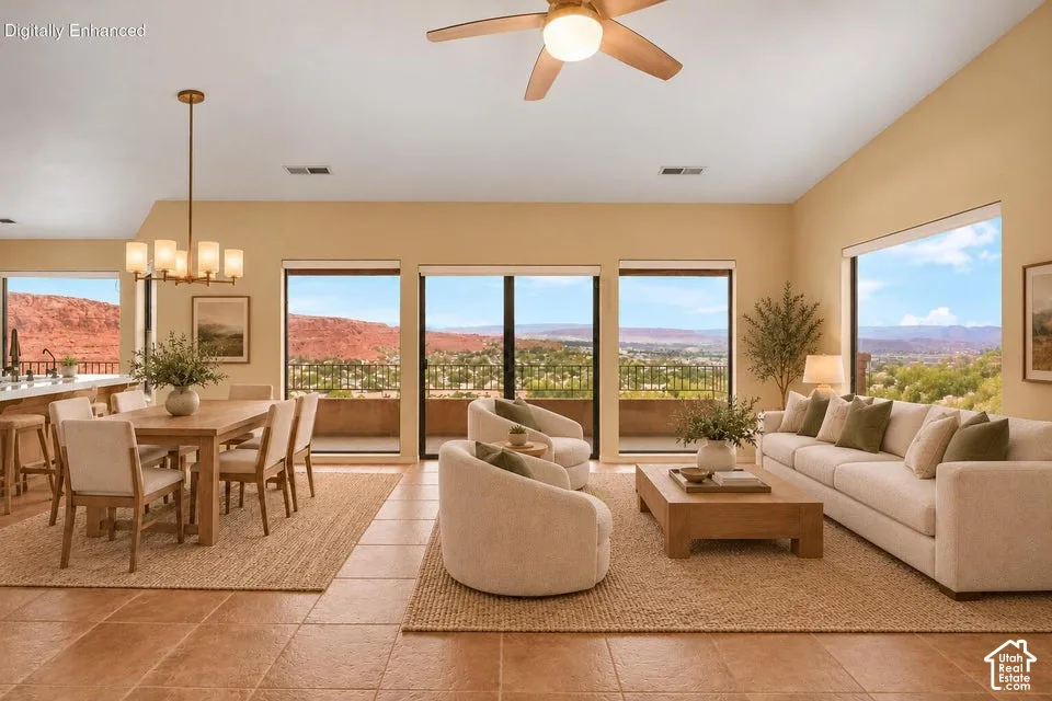 Open-concept space featuring vaulted ceilings, tile flooring, a multi-light chandelier, a ceiling fan with integrated lighting, and expansive windows showcasing rock formation scenery