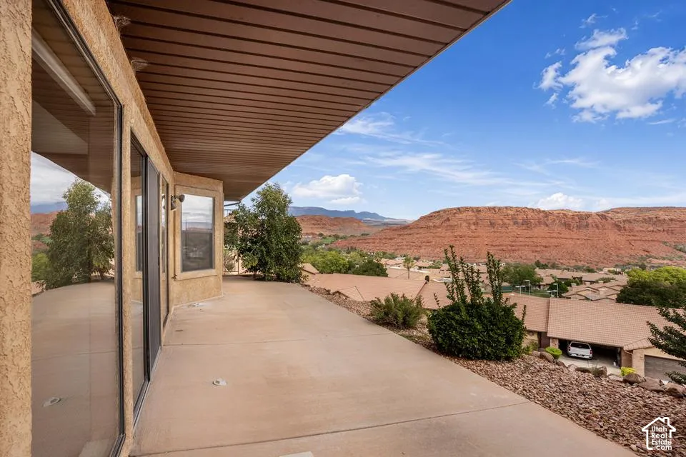 Covered concrete patio featuring floor-to-ceiling windows and extensive desert mountain landscape