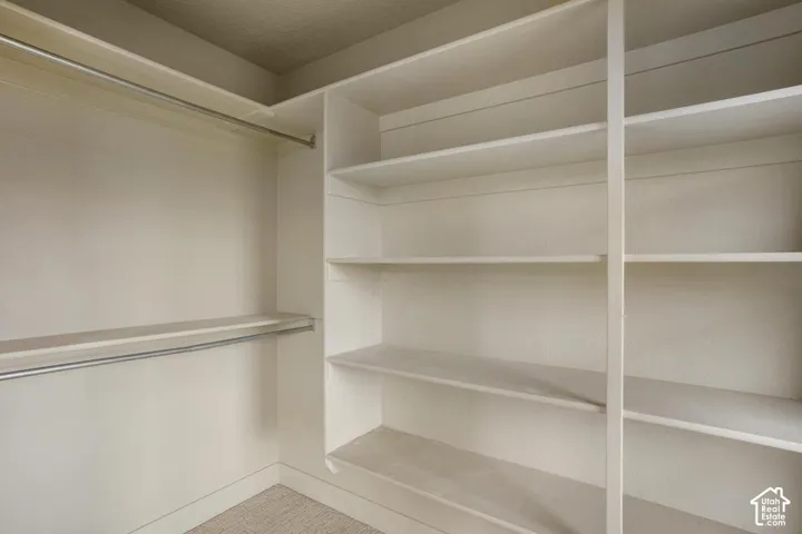 Built-in storage system featuring floor-to-ceiling shelving and dual metal clothing rods
