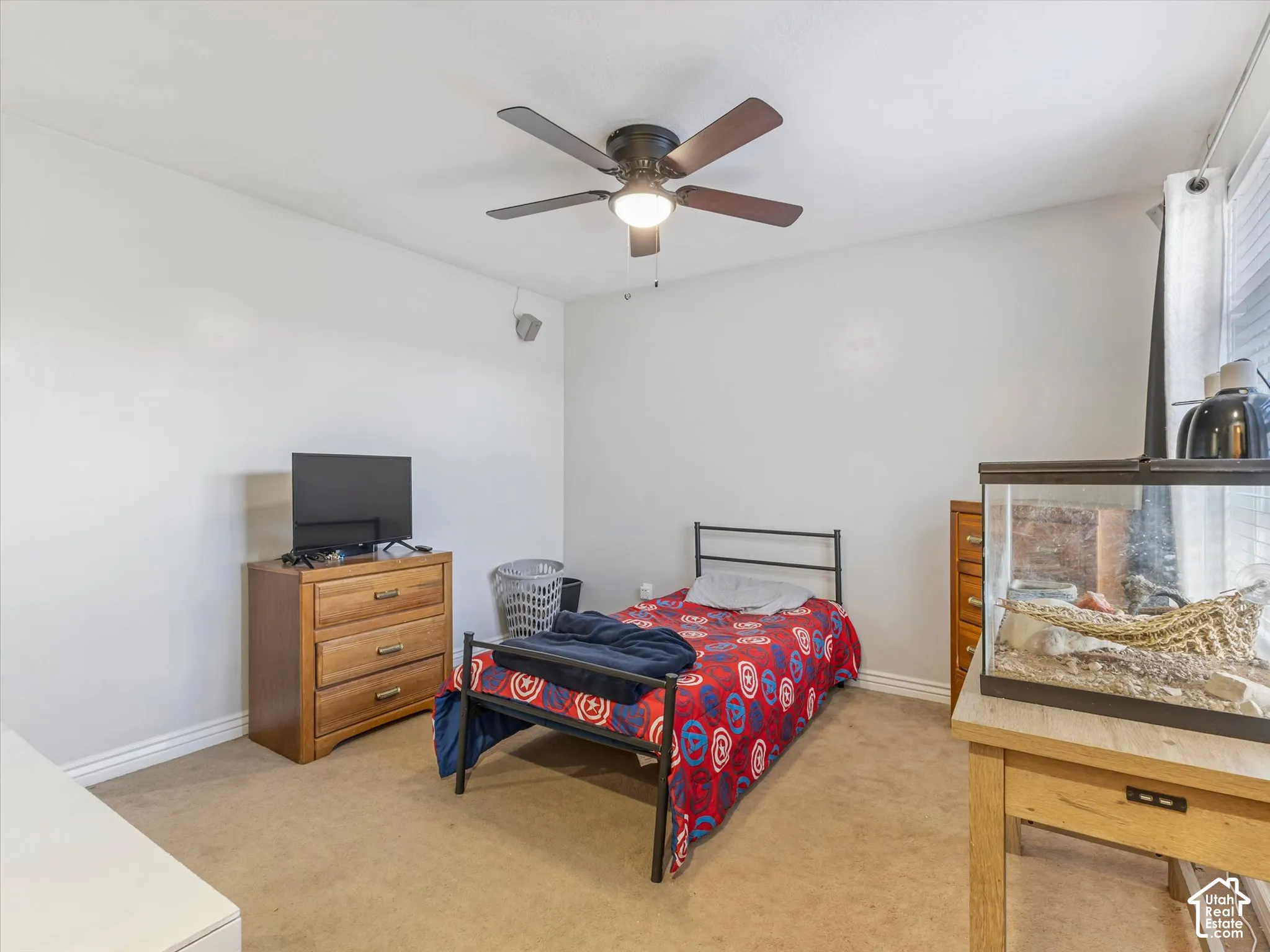 Neutral-toned interior room featuring wall-to-wall carpeting and a ceiling fan with integrated lighting