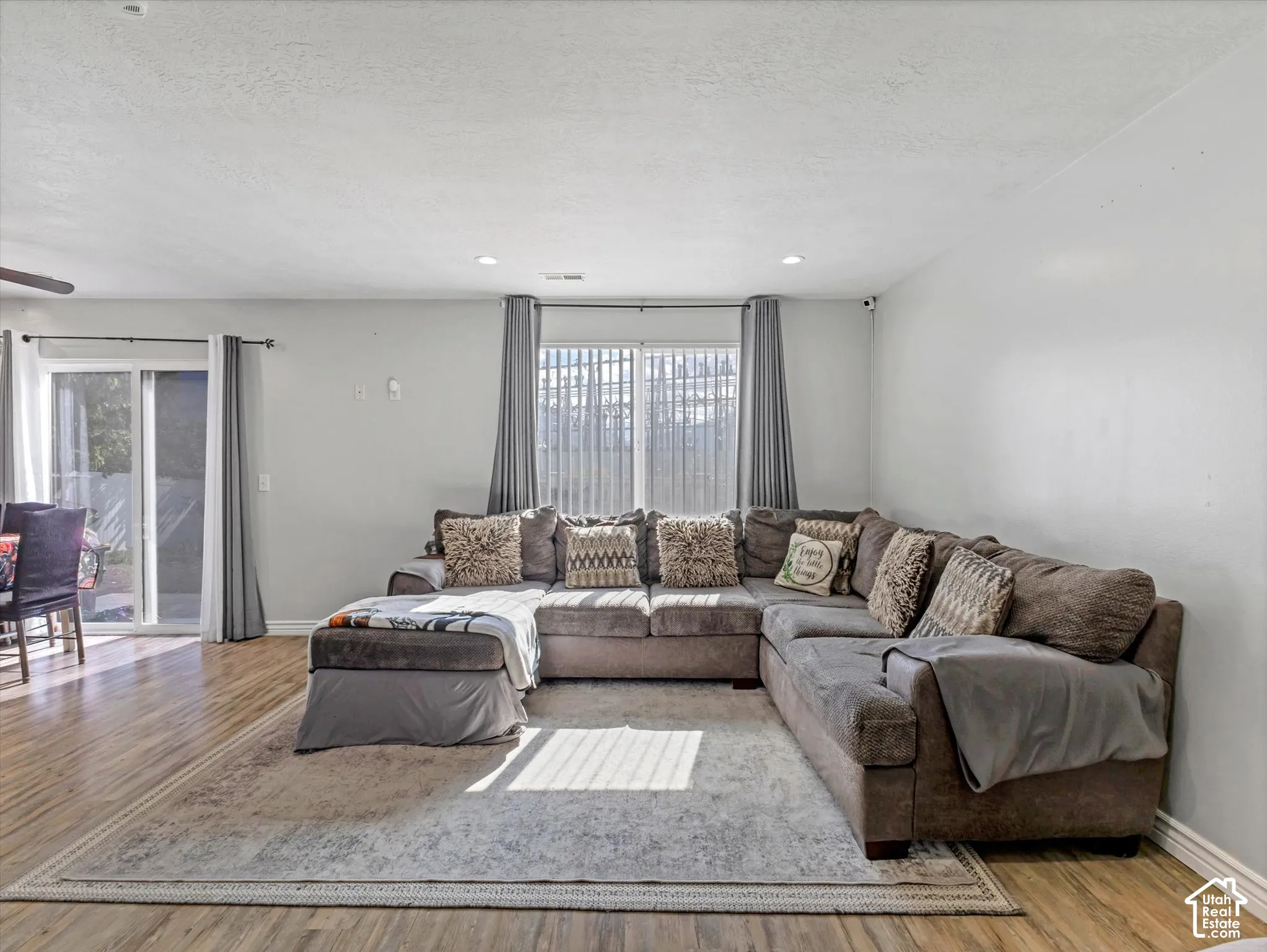 Living area featuring wood-finish flooring, recessed lighting, and a sliding glass door providing external access