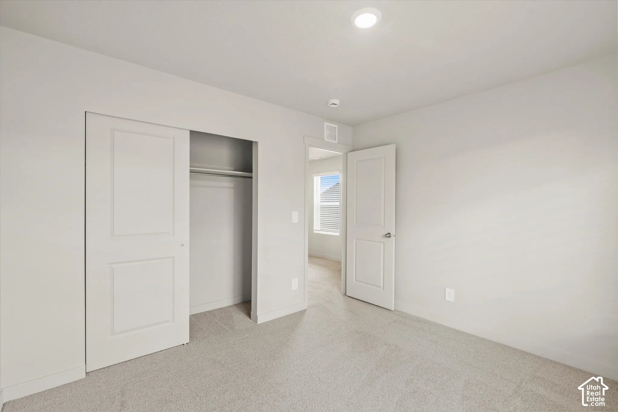 Neutral interior room featuring plush carpeting, recessed lighting, and a sliding-panel closet