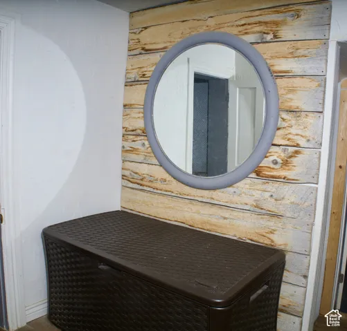 Accent wall featuring horizontal wood planks and a circular wall-mounted mirror