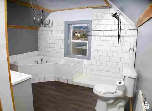 Bathroom featuring wood-finish flooring, white subway-style wall tile, a corner soaking tub with chrome fixtures, and a multi-arm chandelier