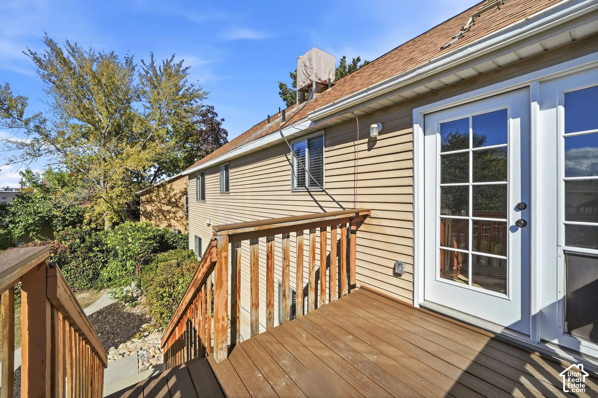 Exterior elevated deck featuring wood-finish flooring, wood railings, and a full-light glass panel door